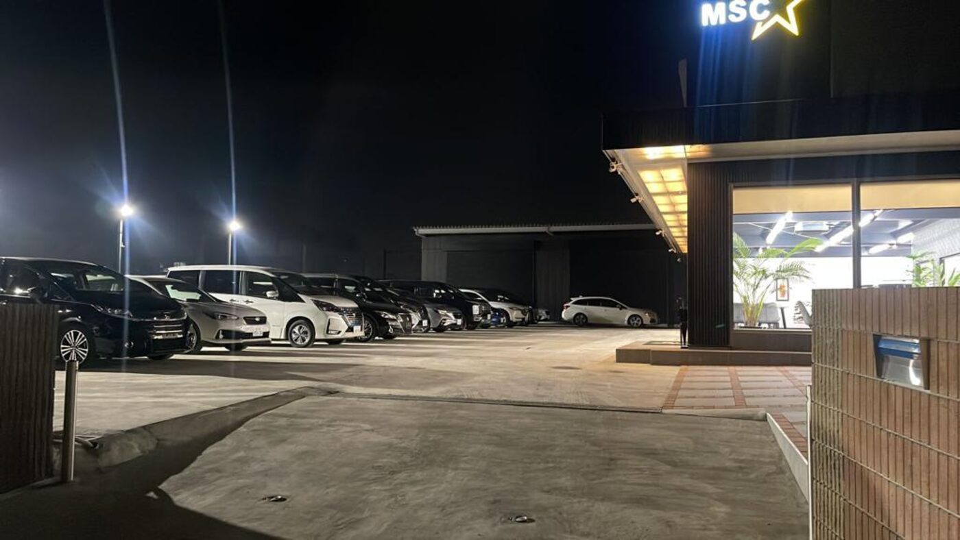 夜間のMSC駐車場と展示車両